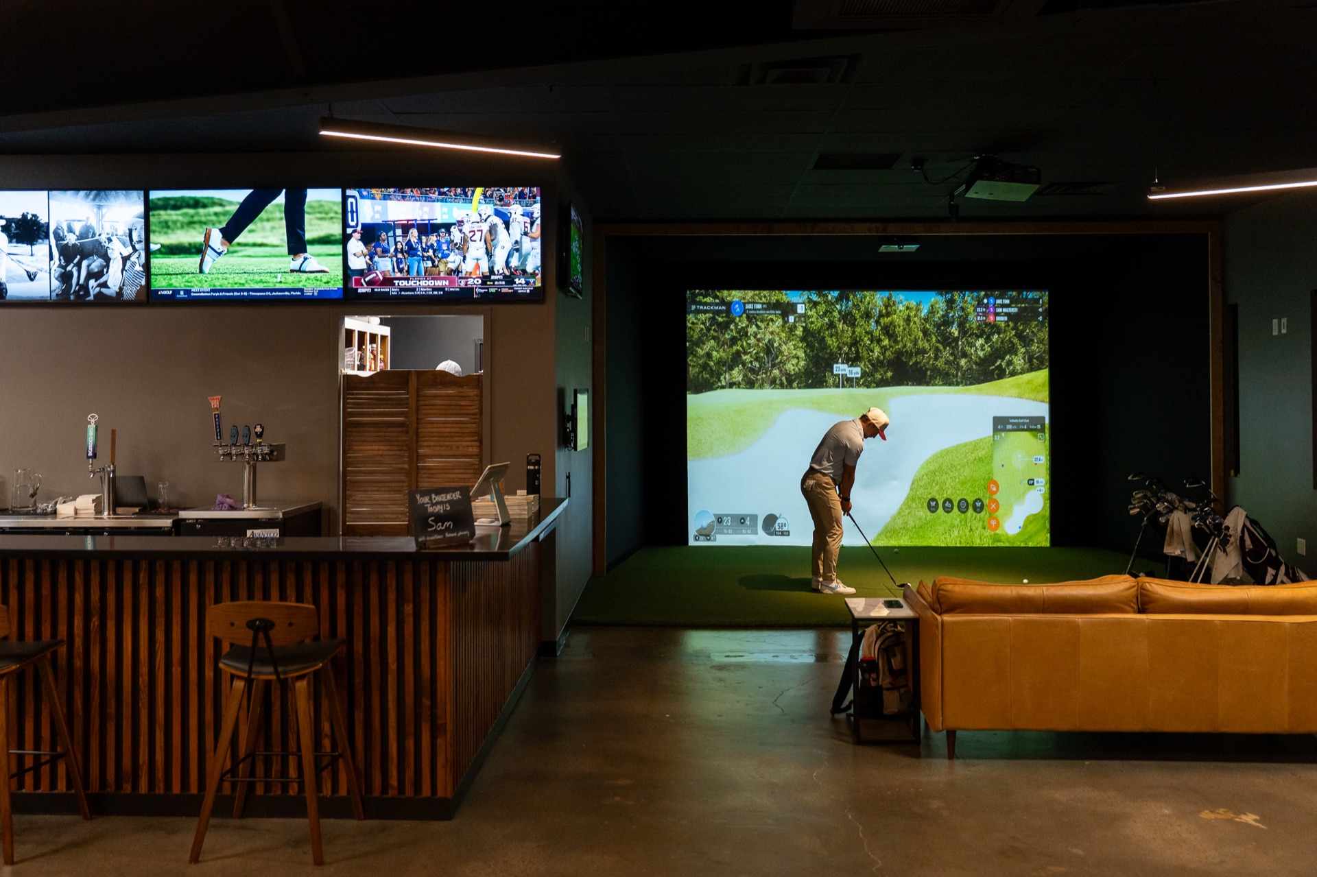 A golfer practicing beside the bar and lounge at The Hideout’s 8th Avenue clubhouse